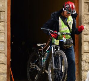 A person with a helmet and a bicycle in a doorway