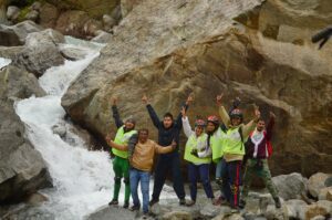 A group of people posing for a picture near a stream