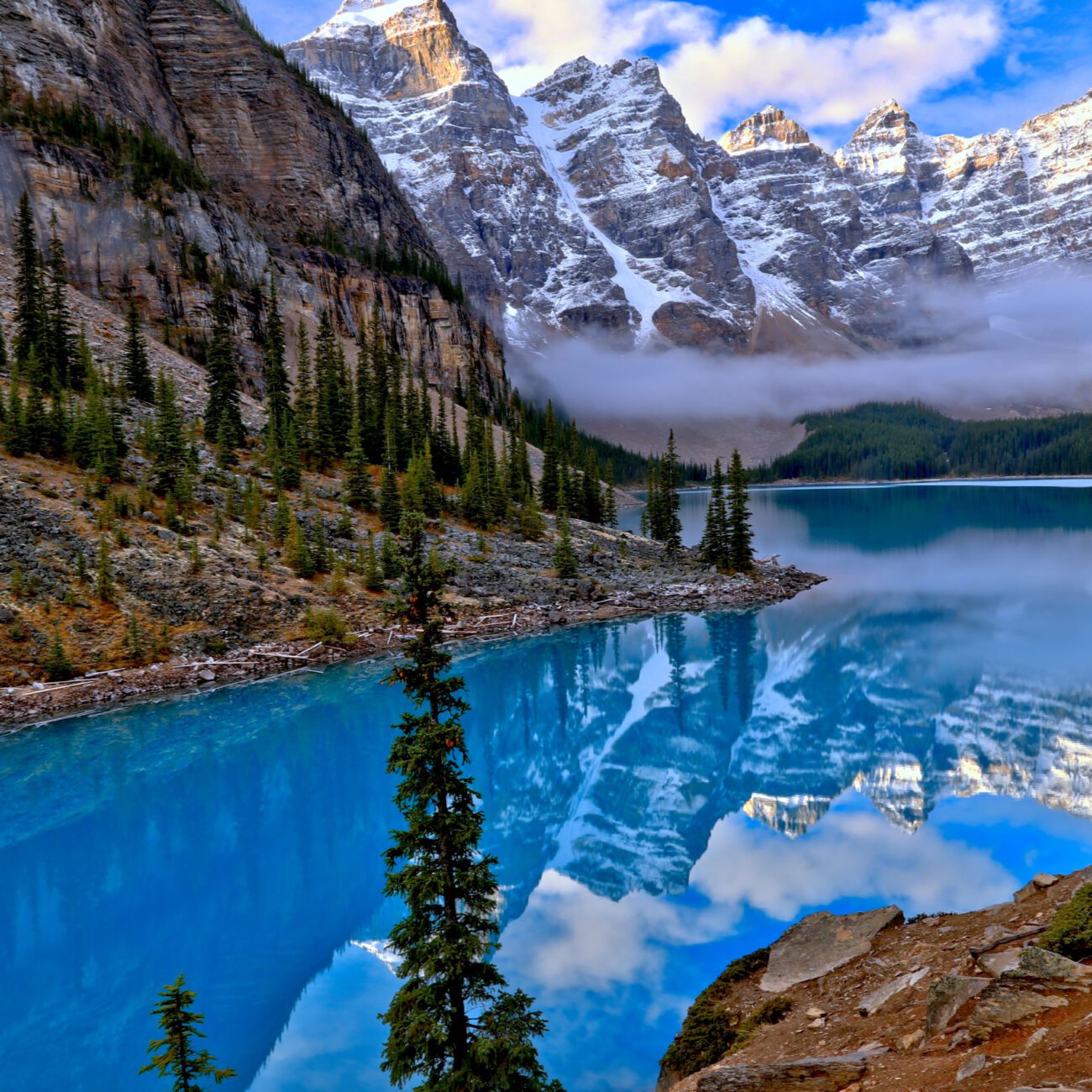 a lake with trees and mountains in the background