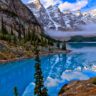 a lake with trees and mountains in the background