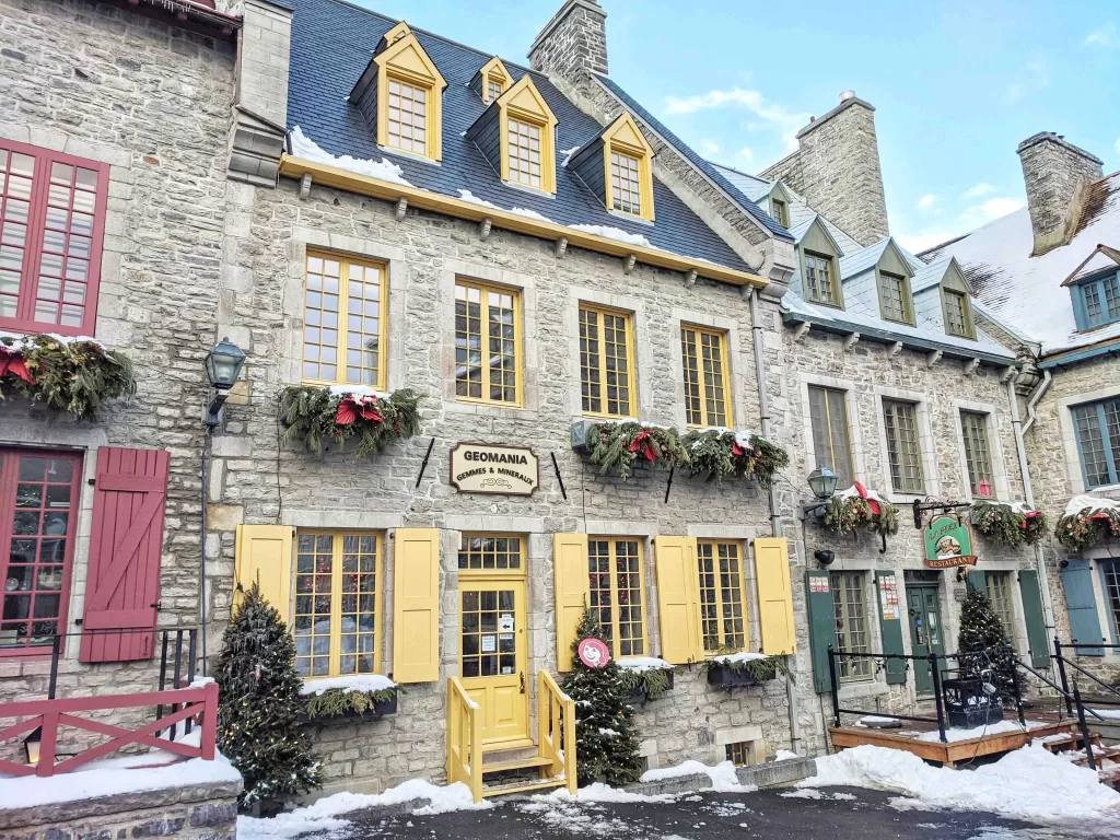 A building with snow on the ground. Quebec City is a great option for your Canadian Getaway.