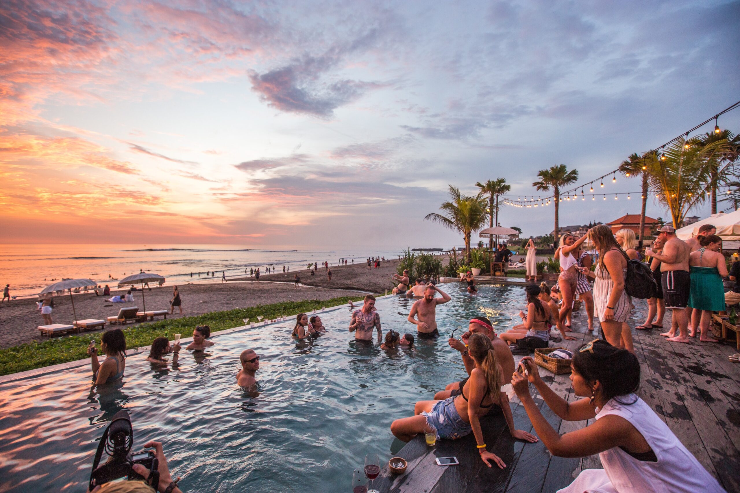 a group of people in a pool at sunset