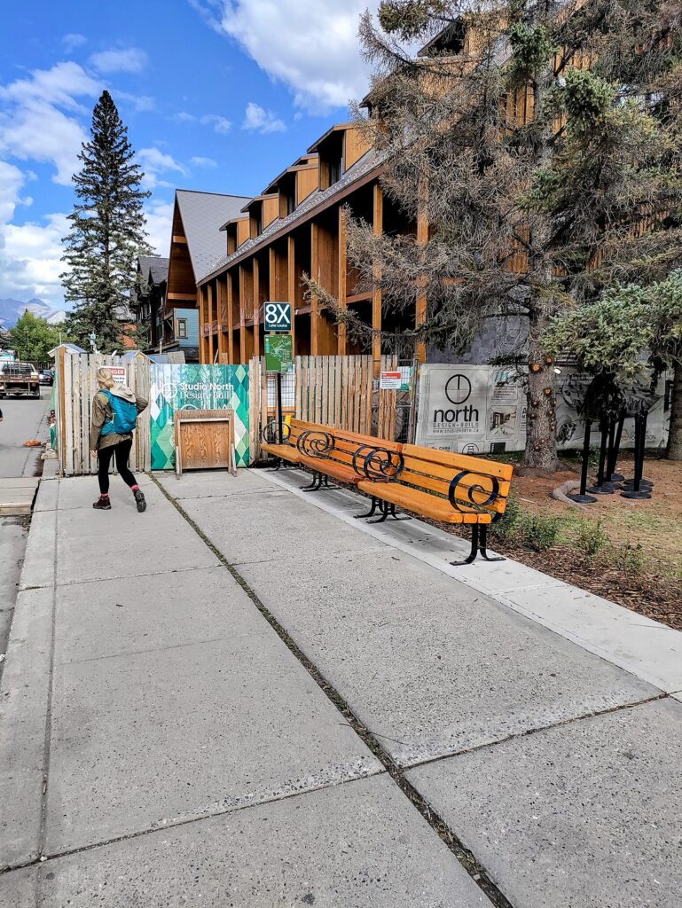 a person walking on a sidewalk next to a bench