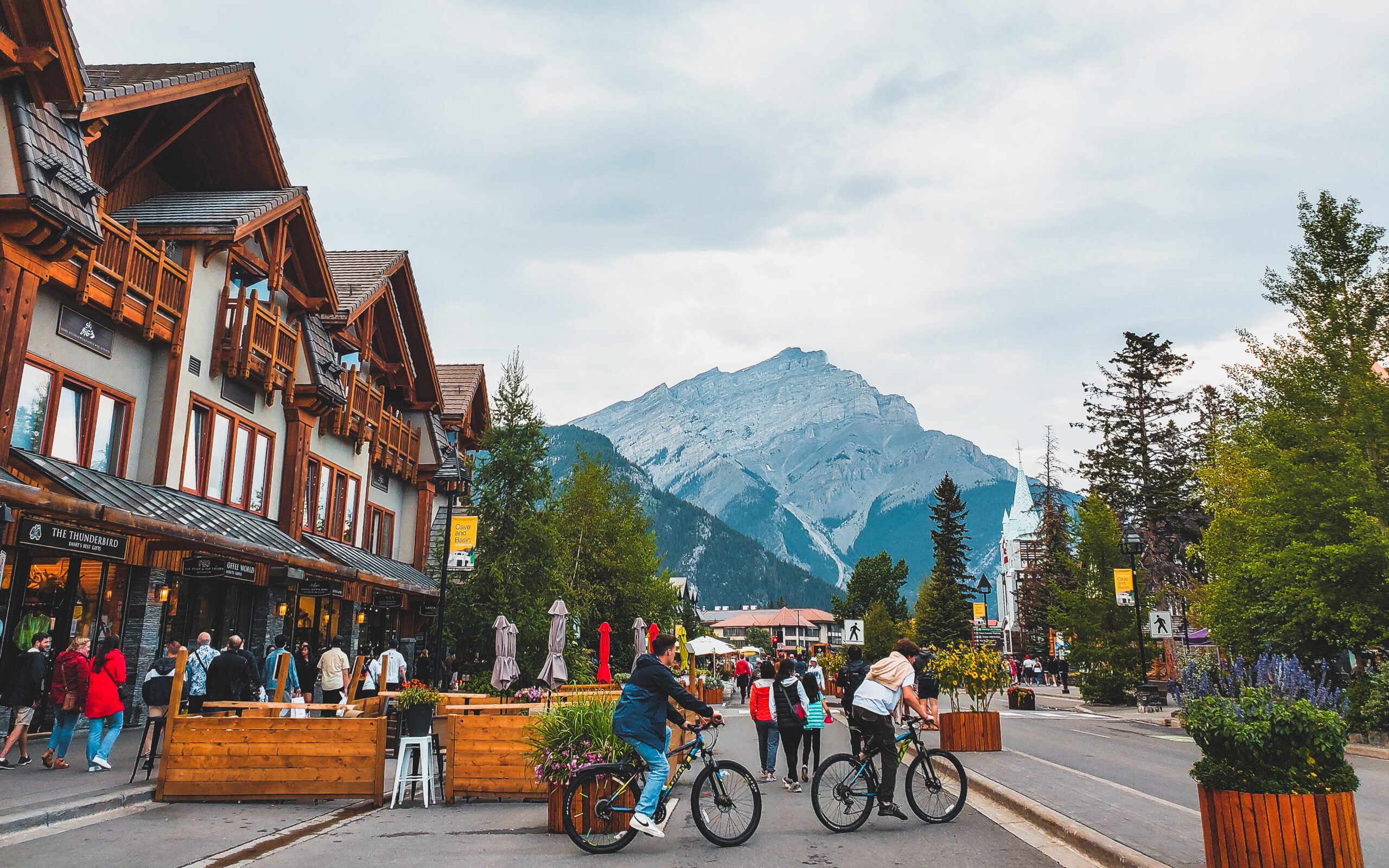 people cycling on street with a mountain in background