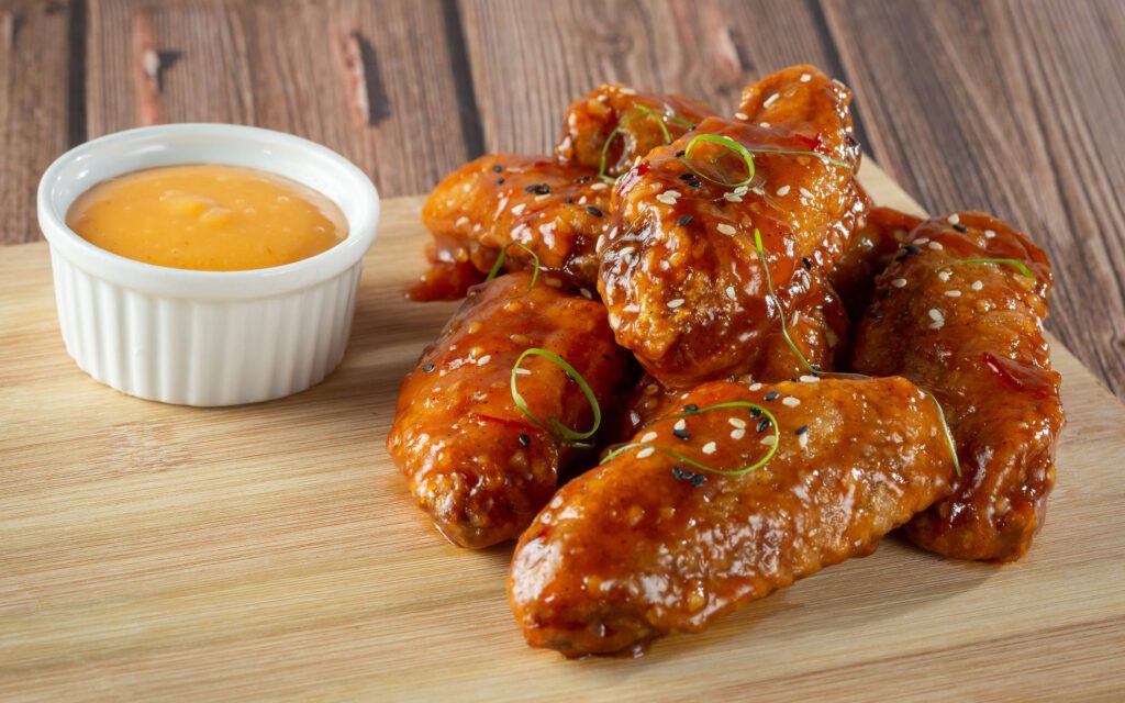 A plate of chicken wings with dipping sauce.