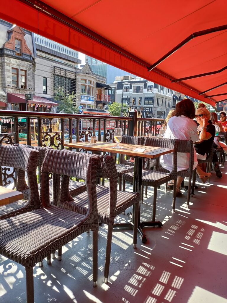 A group of people sitting at tables and chairs on a patio