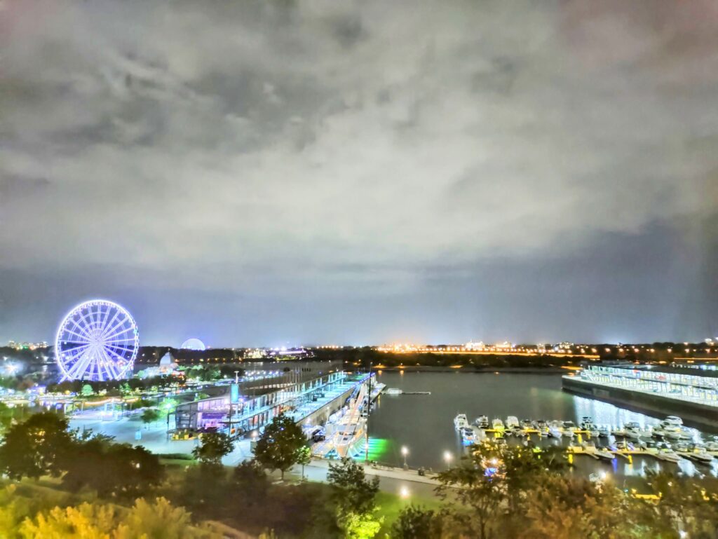 A city with lights and a ferris wheel