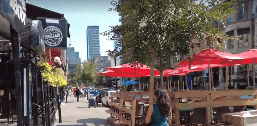 A street with tables and umbrellas