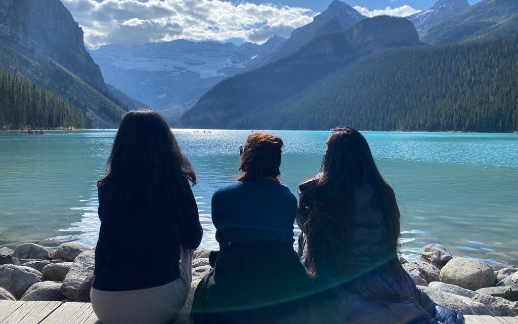 A group of women sitting on a dock overlooking Lake Louise