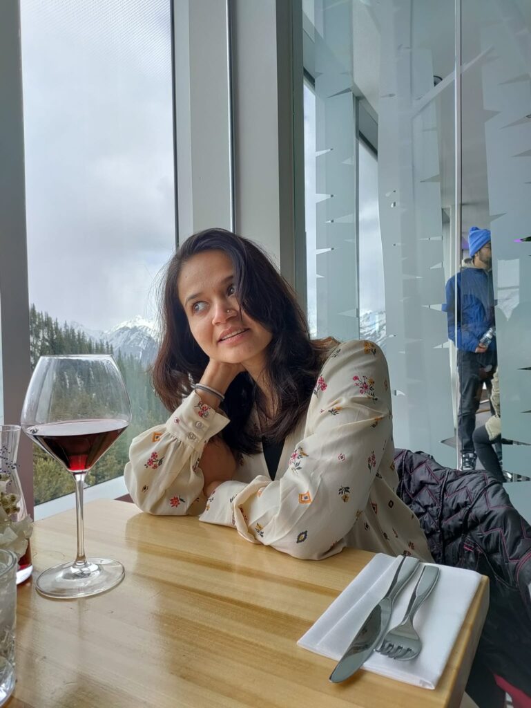 A person sitting at a table with a glass of wine