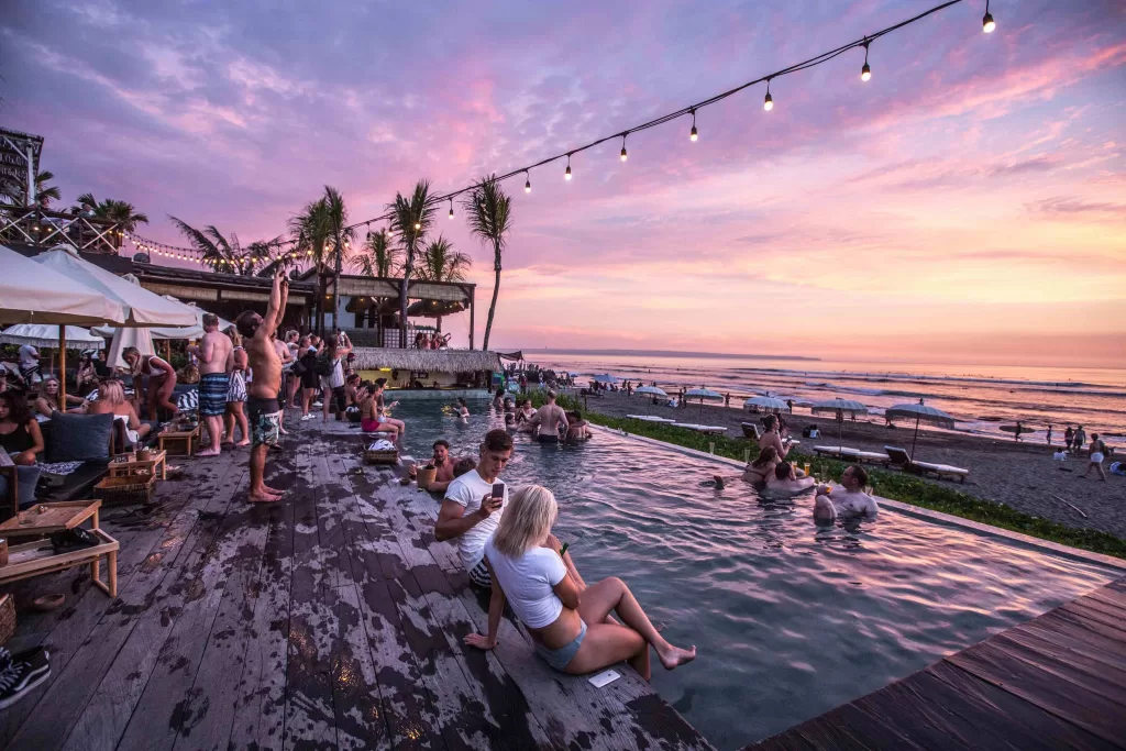 A group of people sitting in a pool at sunset