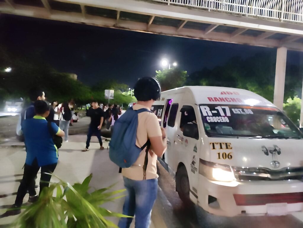 A group of people walking on a street with a van on the side