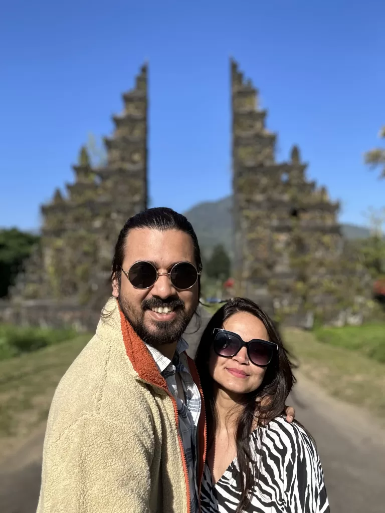 A person and a person taking a selfie in front of a gate