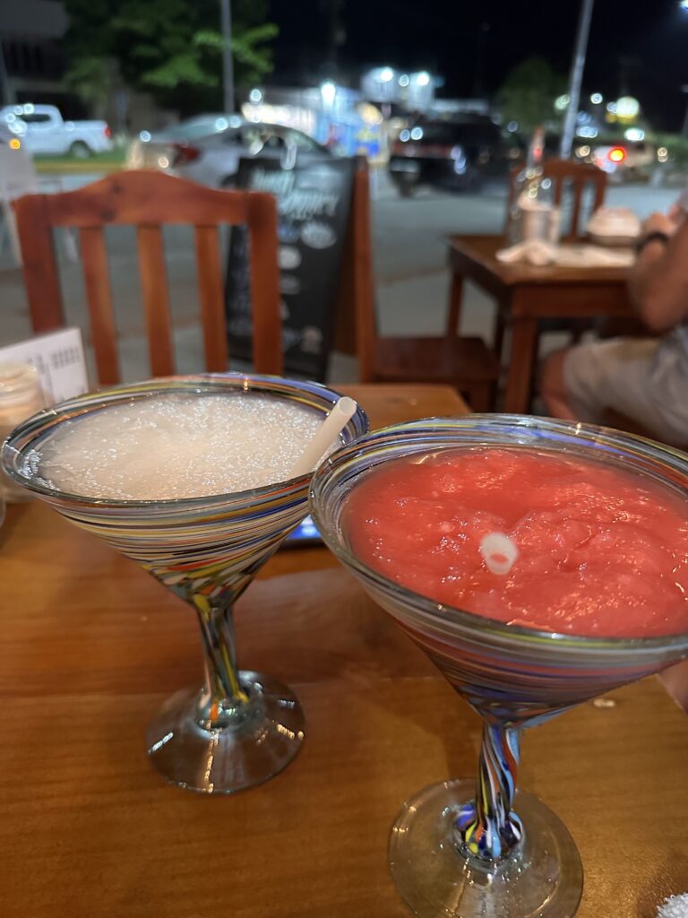 A couple of glasses with drinks on a table