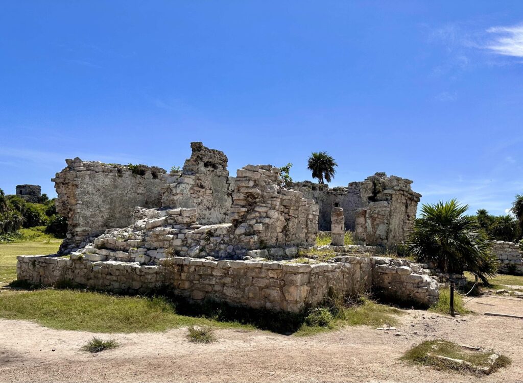 A stone building with a palm tree in the background