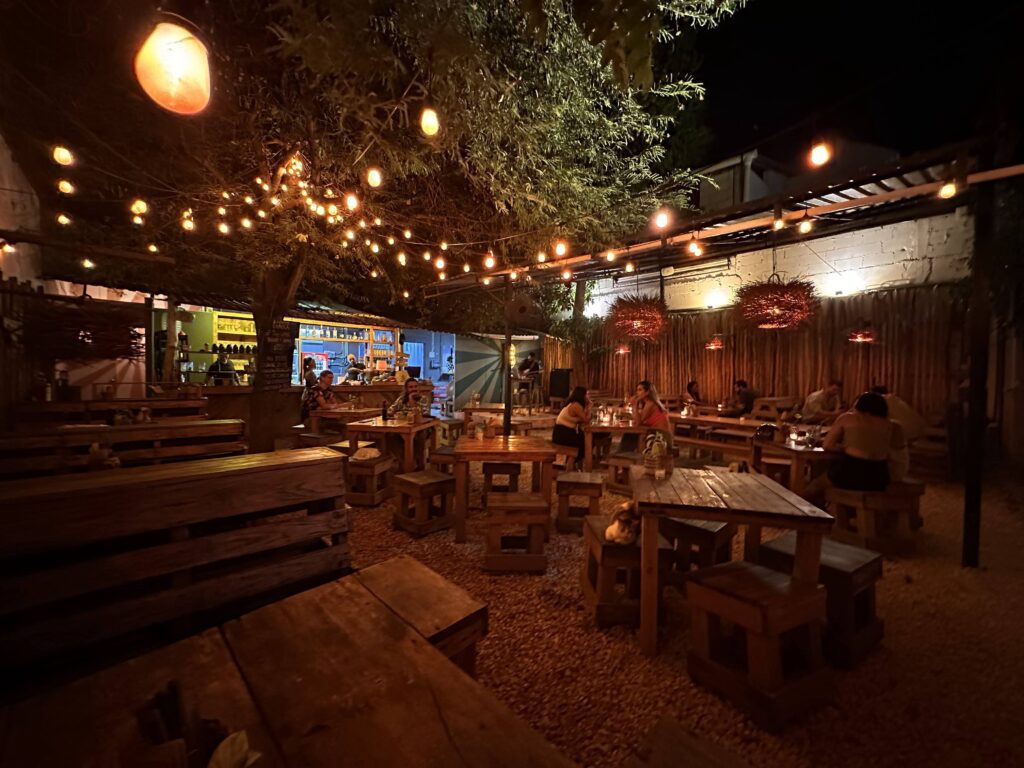 A group of people sitting at tables outside at night. An experience you must have in your local 3-day Tulum Itinerary