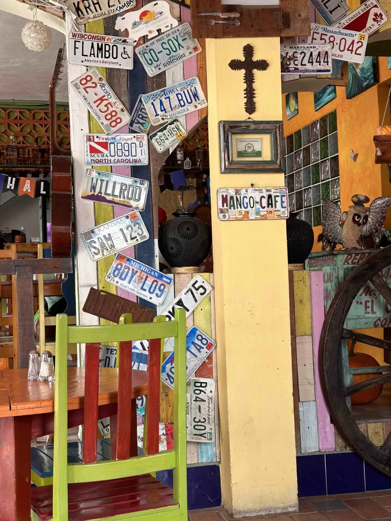 A wall with license plates and a cross