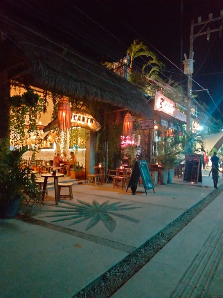 A street with a restaurant and tables at Tulum.