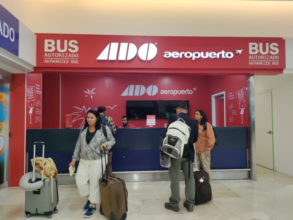 People standing in front of a bus station. ADO bus a great way to travel in Cancun in public transit