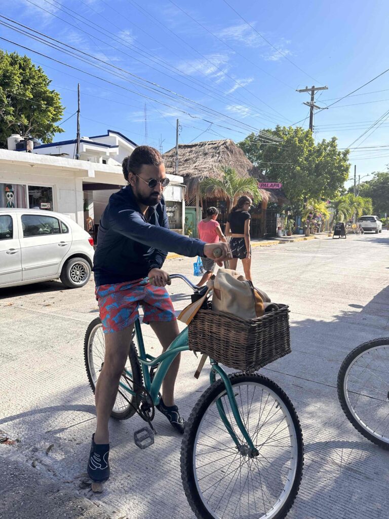 A person on a bike with a basket. A great way to visit cenotes in Chemuyil.