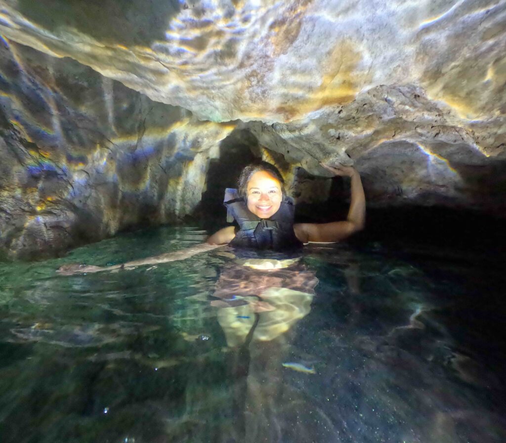 A person in a cave with water below