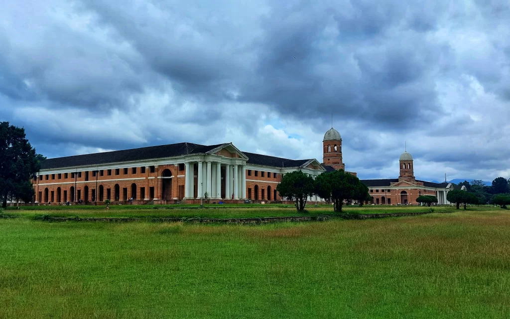 A large brick building with columns and a lawn