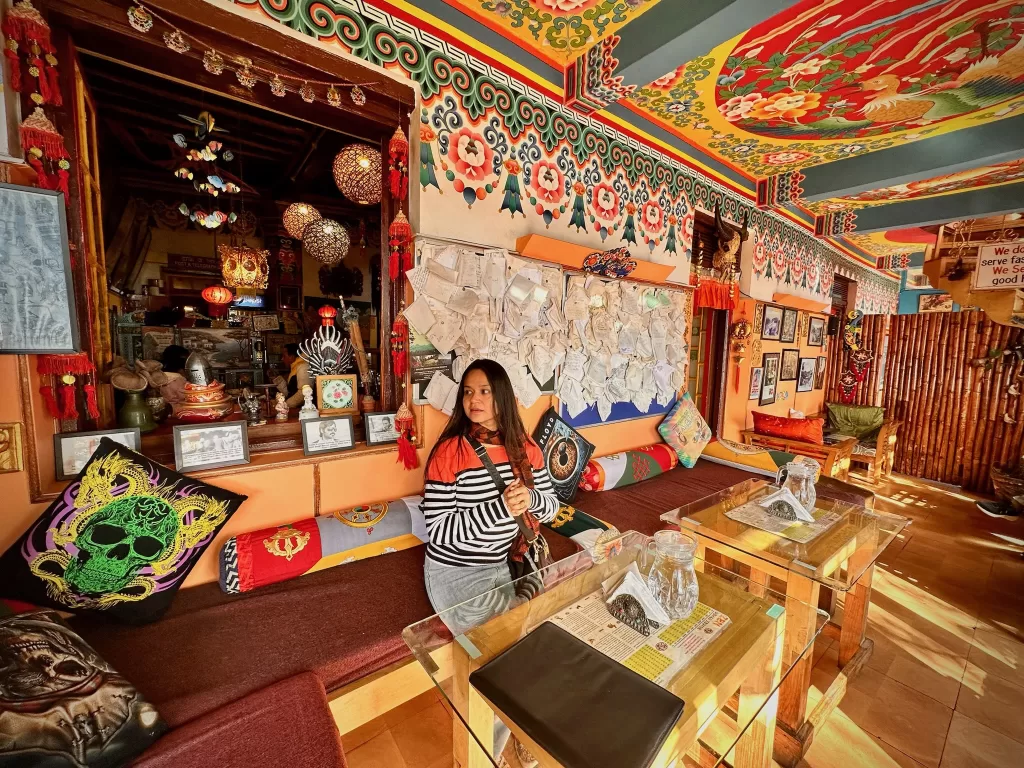 A person sitting on a bench in a room with colorful ceiling