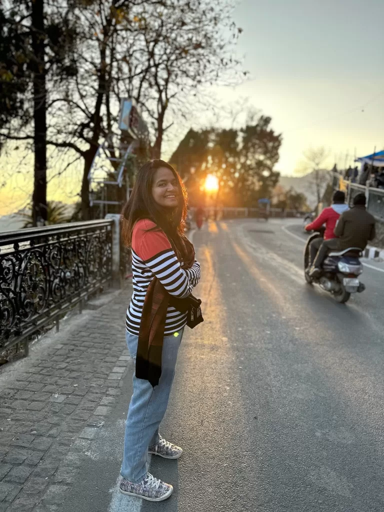 A person standing on a road with a bike and a sunset