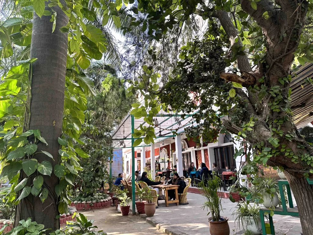 A group of people sitting at tables in a courtyard