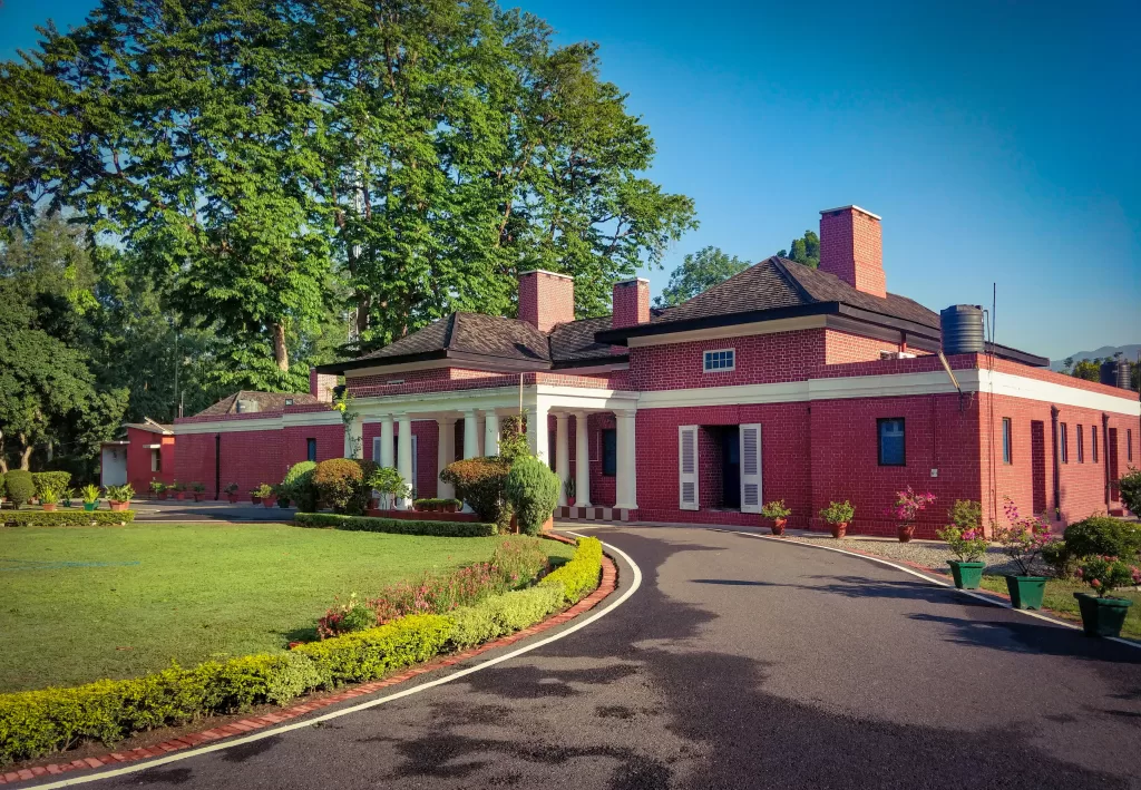 A red building with a pathway and garden