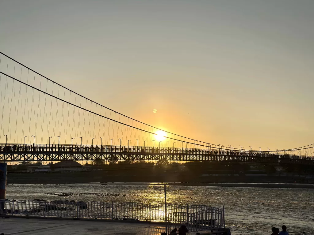 A bridge over water with a sunset