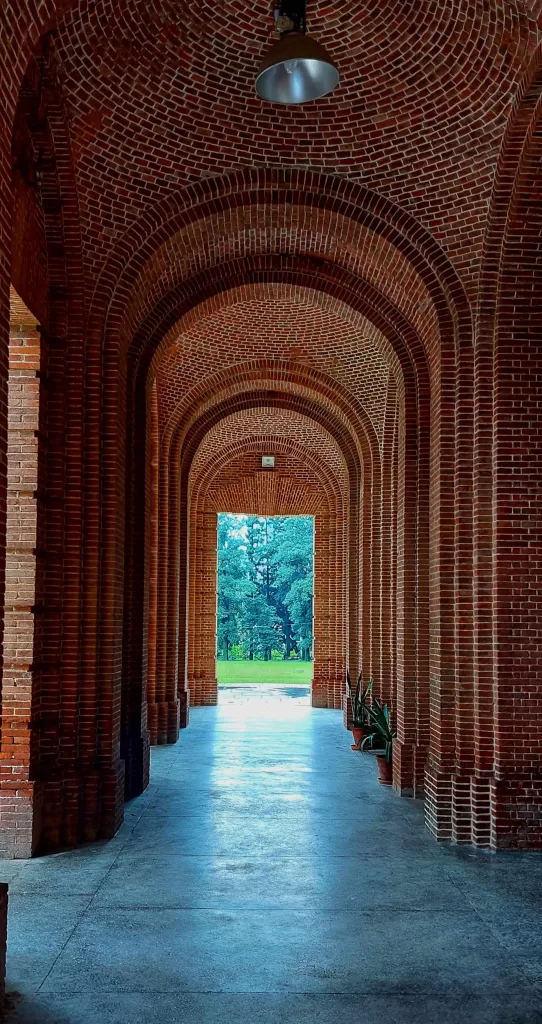 A brick archway with trees in the background