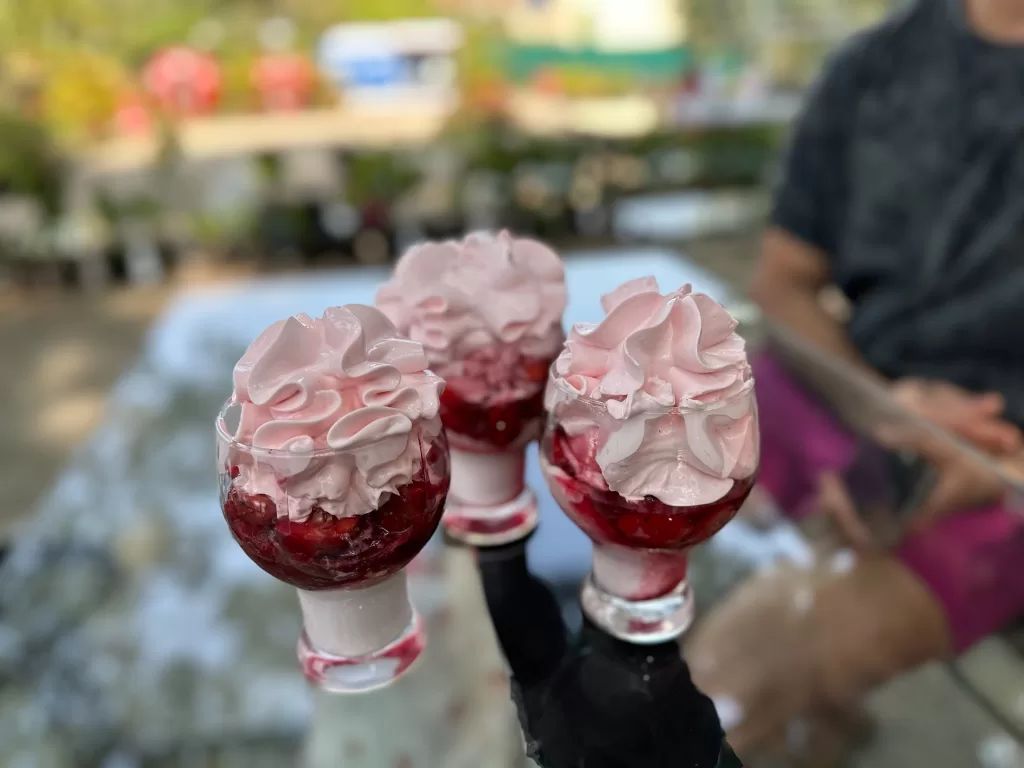 A group of desserts in glasses