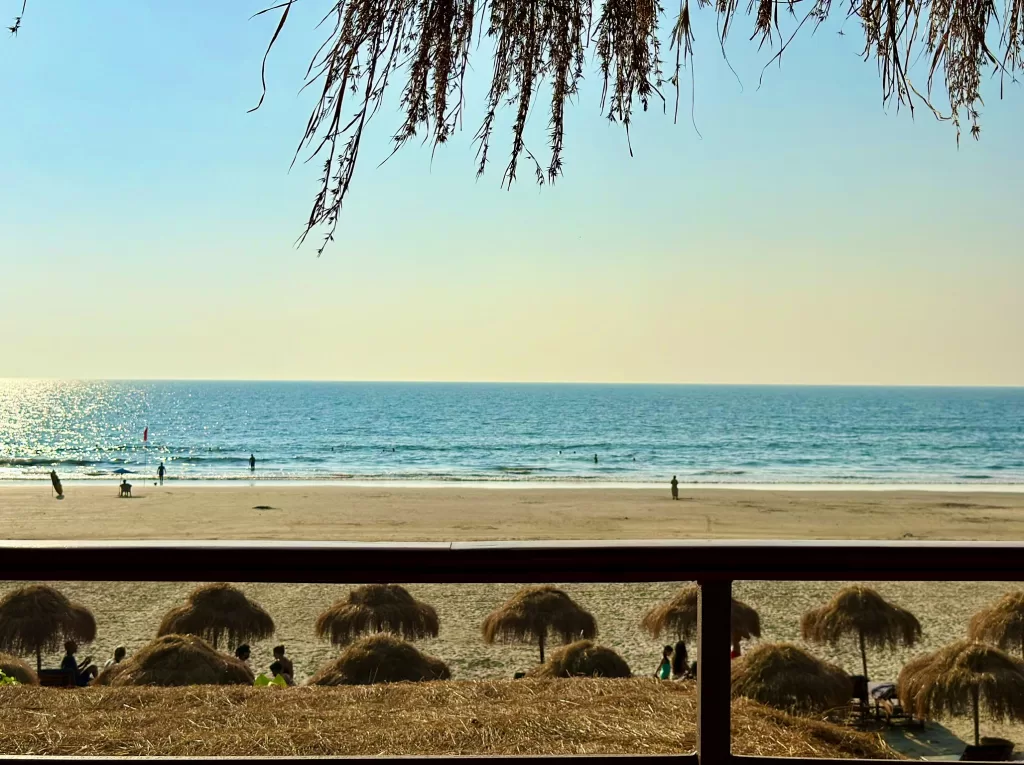 A beach with umbrellas and people on it enjoying the best time to visit Goa in 2024.