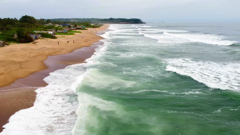 A beach with waves crashing on the shore