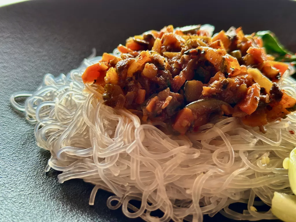 A plate of noodles with vegetables on it. Part of Amazing Off-beach restaurants in Mandrem