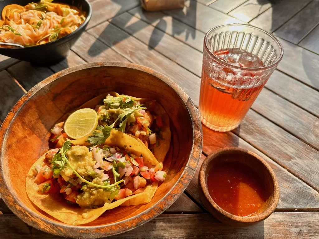 A bowl of tacos and a drink on a table