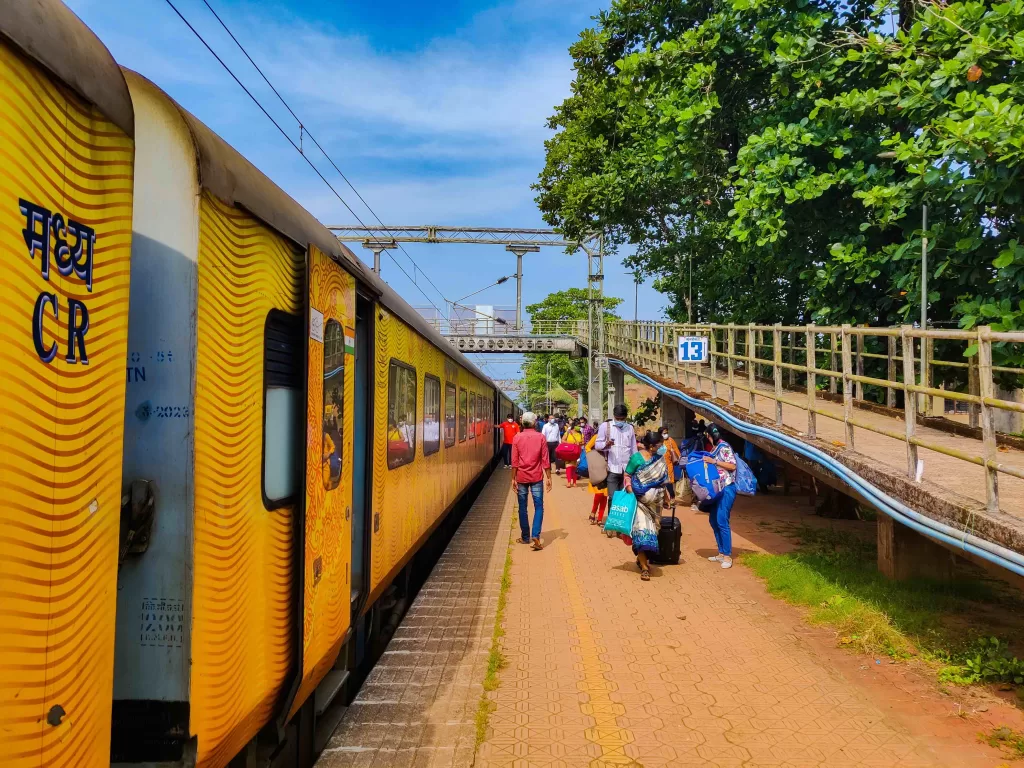 A group of people walking next to a train