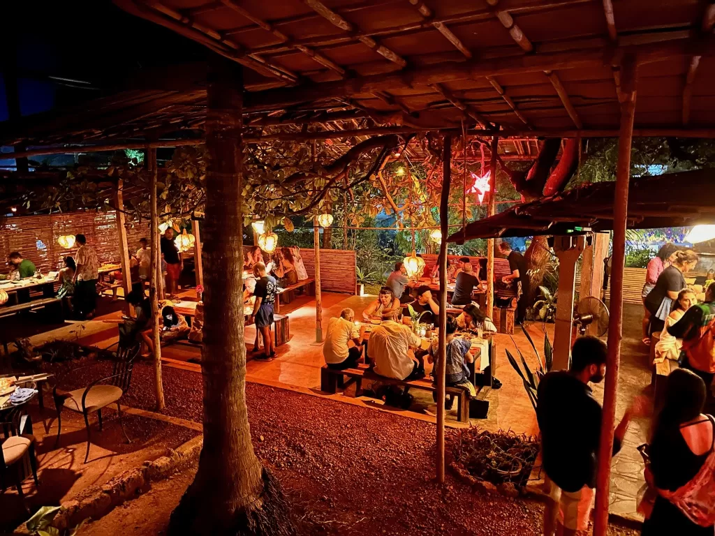 A group of people sitting at tables under a covered patio