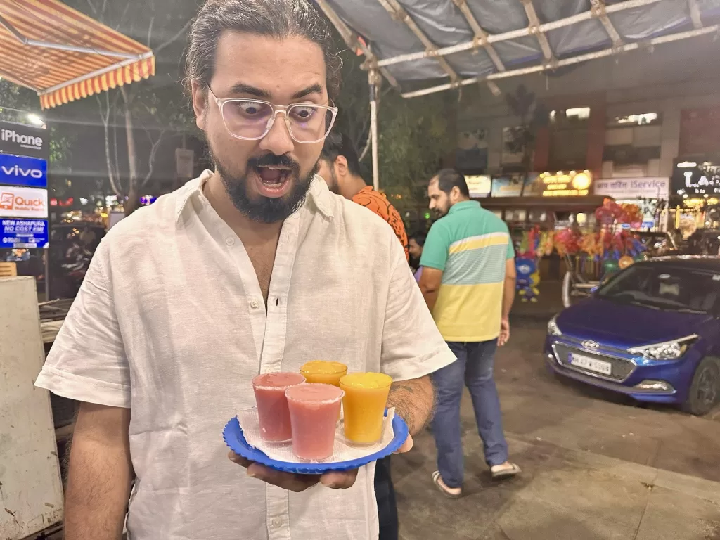 A person holding a plate of drinks