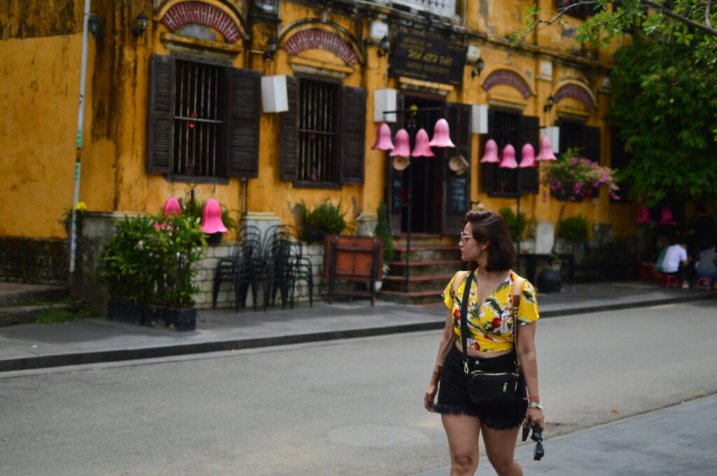 Person standing in front of yellow building