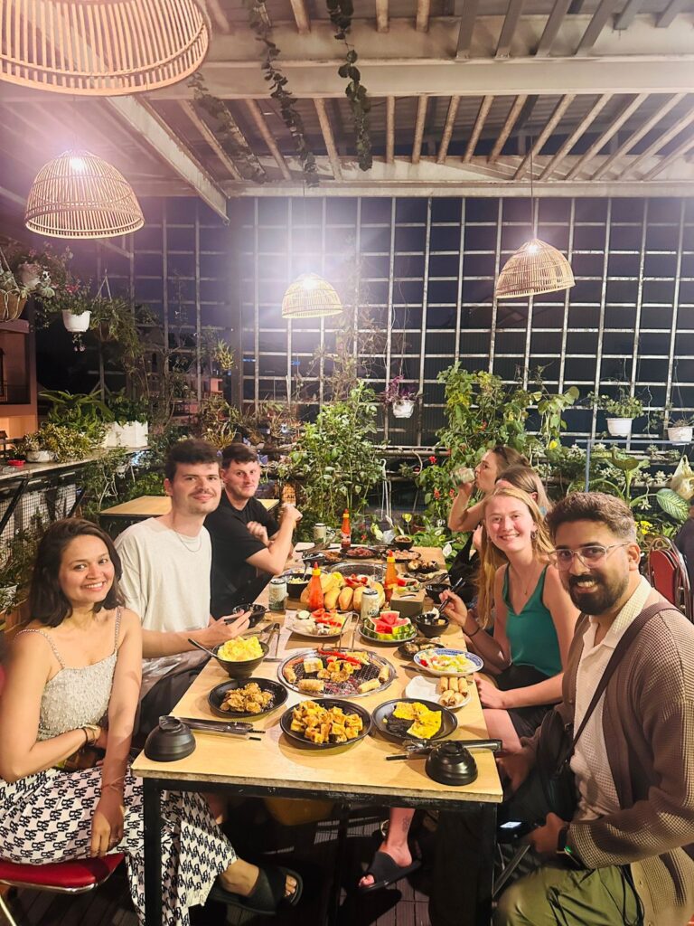 A group of people sitting on a table with food