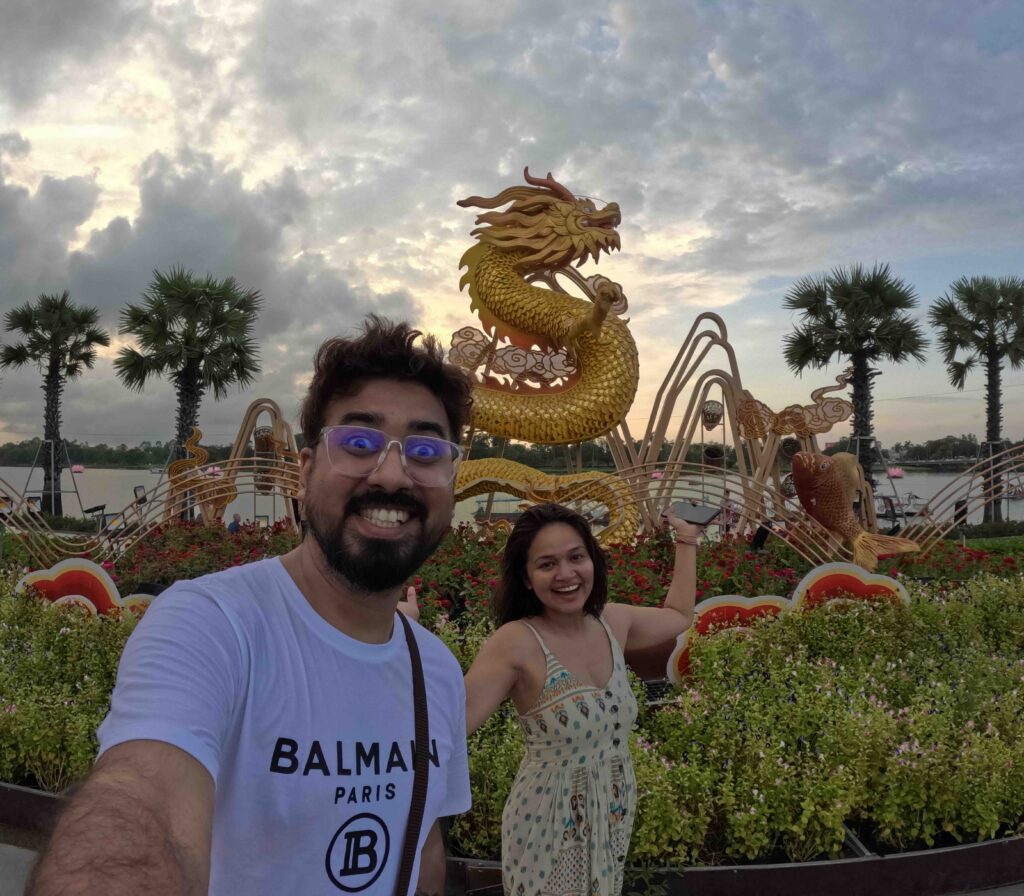 Two people posing in front of River and Dragon. One of the best things to do in Hue is to stroll the area.