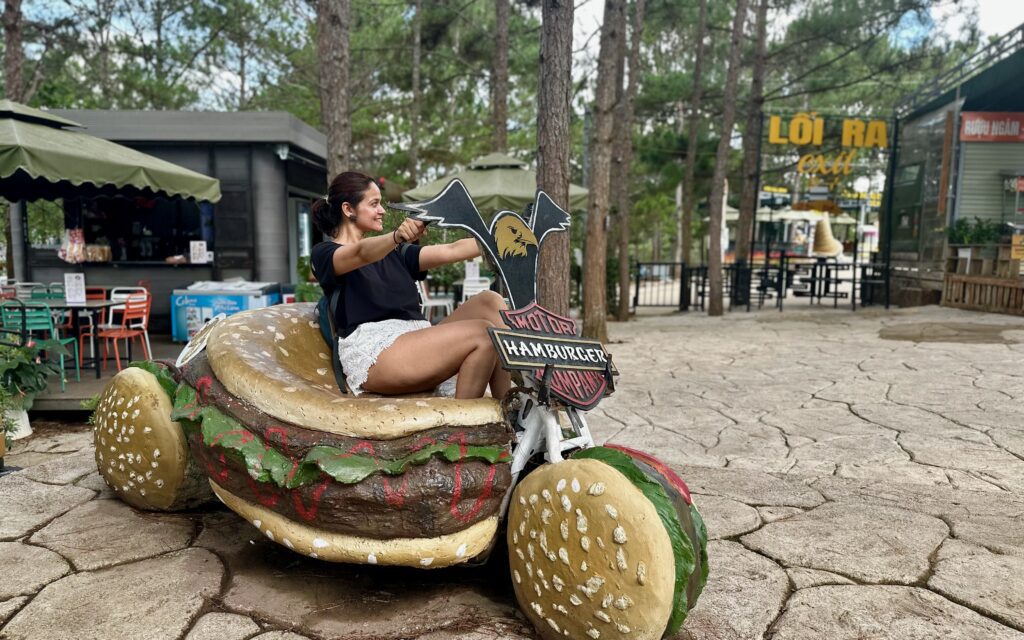 A person sitting on a bike shaped like a hamburger. Crazy Clay Tunnel in Dalat Vietnam