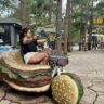 A person sitting on a bike shaped like a hamburger. Crazy Clay Tunnel in Dalat Vietnam