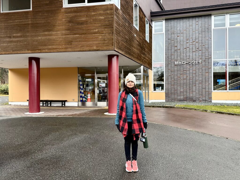 A girl standing in front of visitor center of Asahidake Onsen in Japan