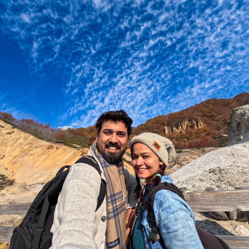 Picture of A Couple Posing With Clear Blue Sky and Mountain in the background