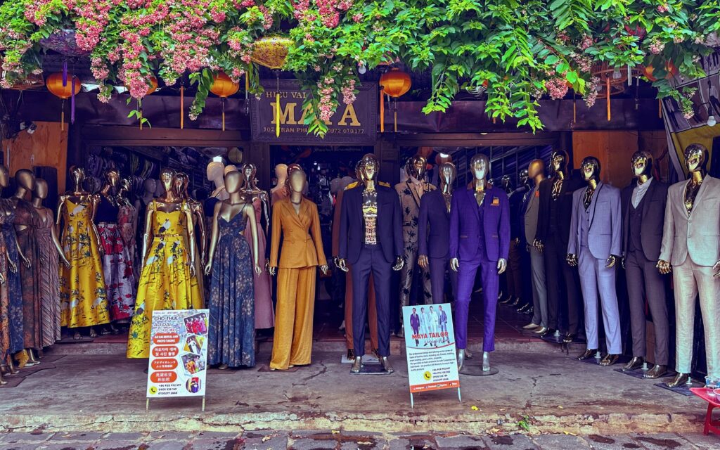 A street shop in Hoi An with manequins showcasing different suits. Tailoring in Hoi An