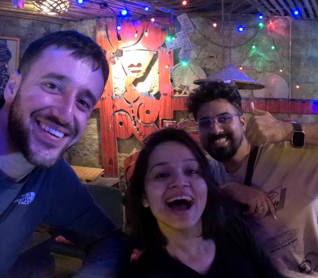 Three people laughing and having fun in colour bar in Sapa, Vietnam