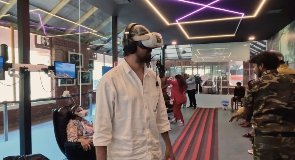 A person in white shirt wearing a VR headset, at Ervaikulam National Park VR center